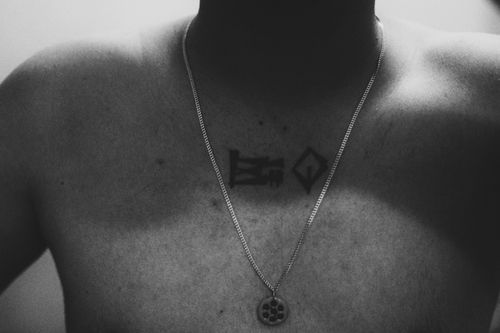 Free Monochrome photo featuring a man's tattooed chest adorned with a necklace. Stock Photo