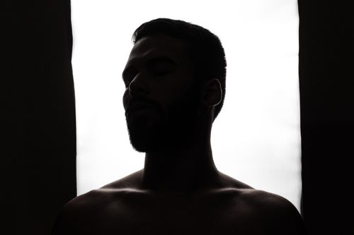 Free Artistic silhouette of an adult man with a serene expression against a bright background. Stock Photo