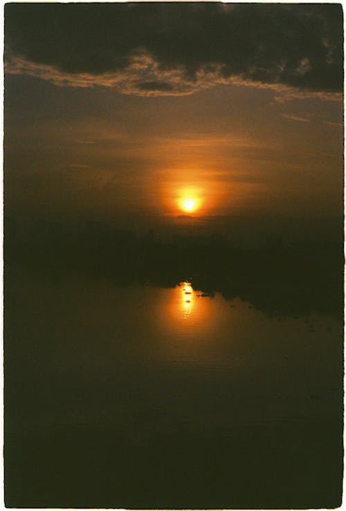 Free Golden Sun Setting over Body of Water Stock Photo