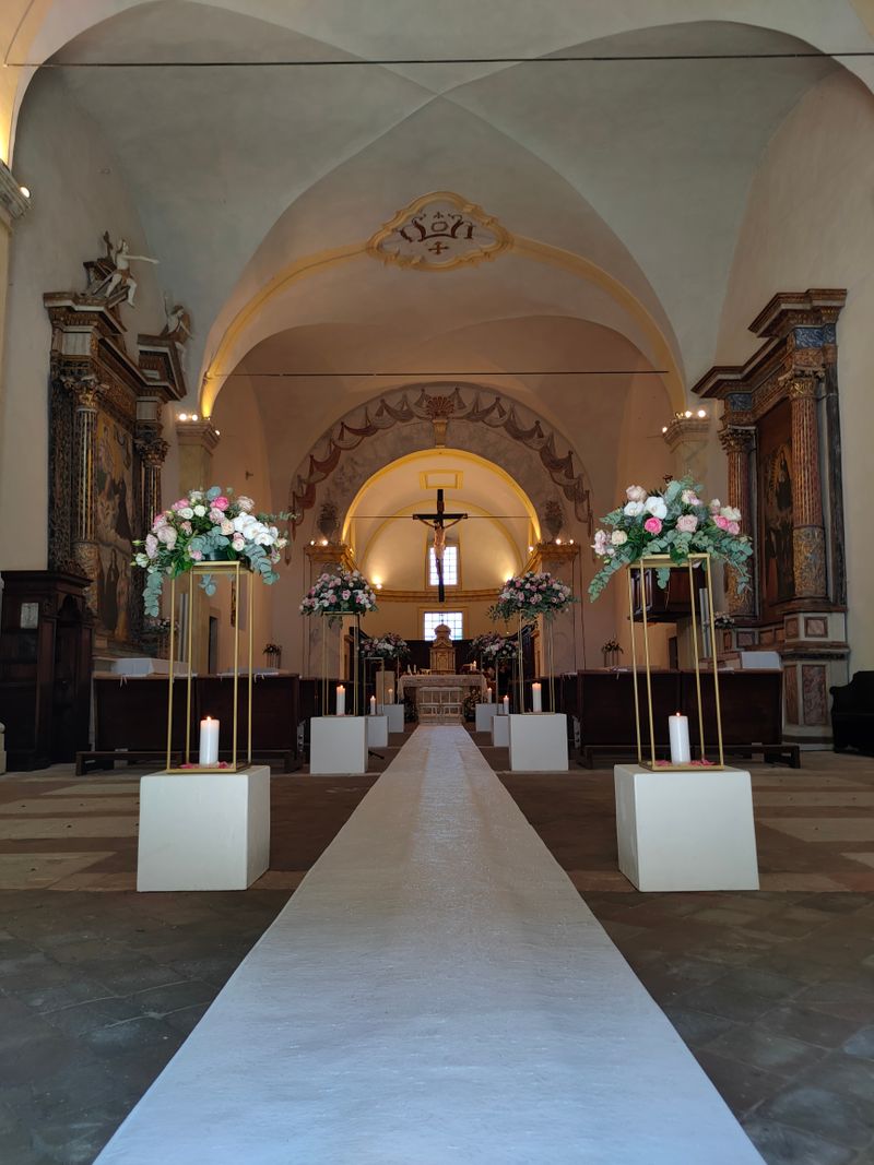 Mesa de banquete vestida con flores y velas en tonos cálidos