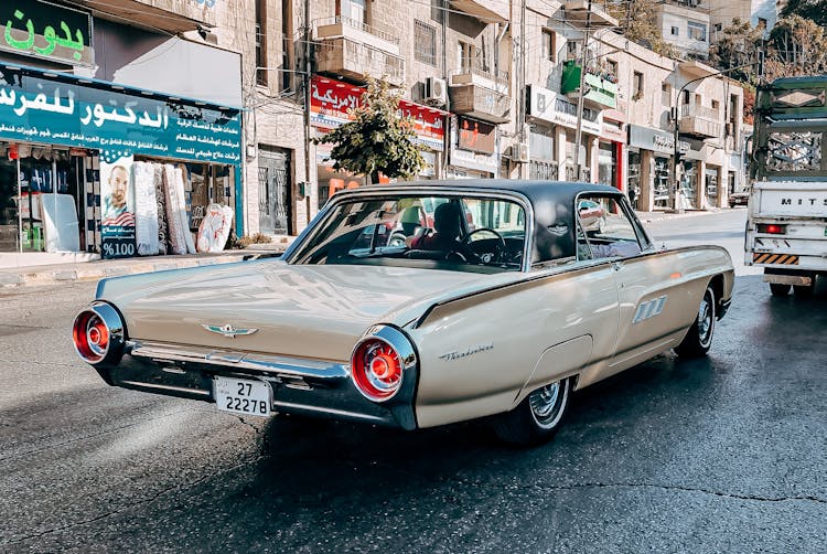 A Person Driving Brown Classic Car On Asphalt Road