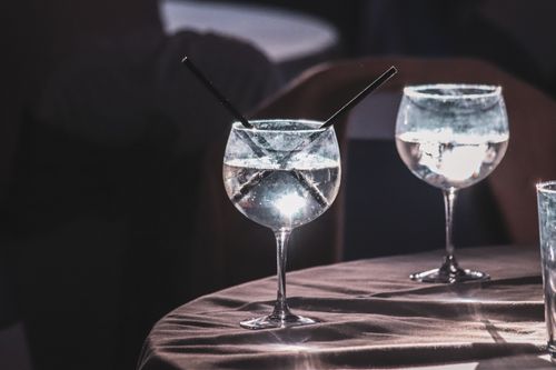 Free Elegant cocktail glasses with straws captured in a dimly lit setting. Perfect for nightlife themes. Stock Photo