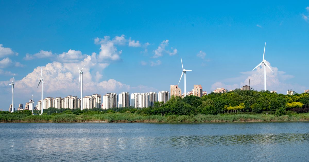 A cityscape image with renewable energy sources like wind turbines, exemplifying future-oriented Climate Tech infrastructure.