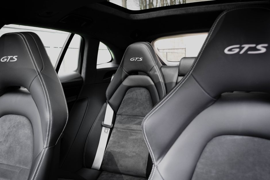 Close-up of a car interior featuring black leather seats with GTS branding.