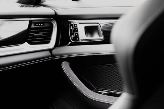 Close-up of a luxury car interior with a focus on the sleek dashboard and leather stitching.
