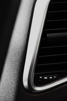 Detailed view of a car air vent with sleek modern design in a dark setting.