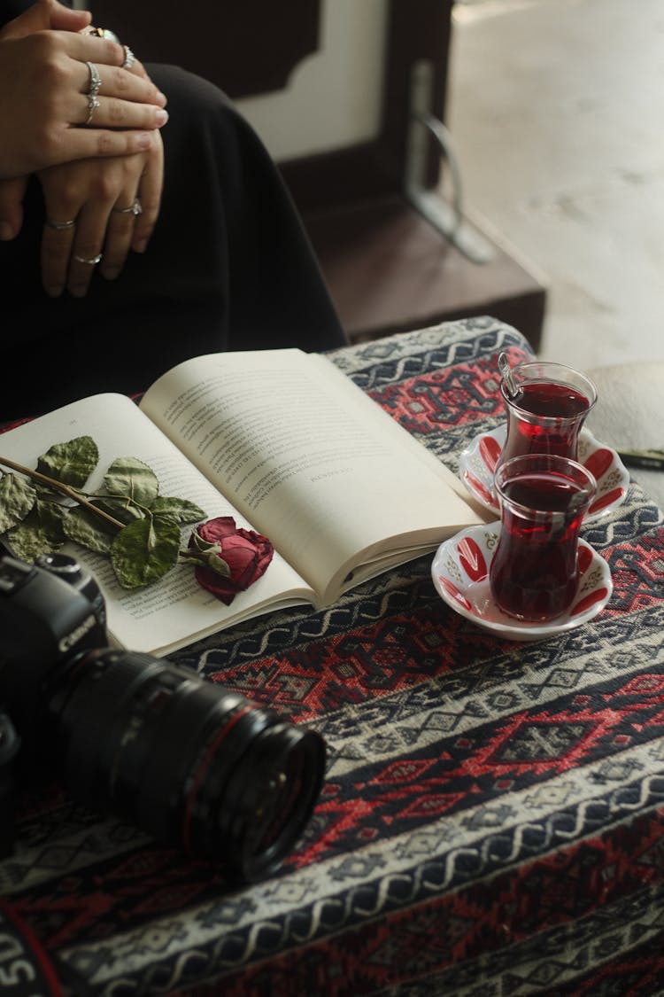 Rose On Book And Tea And Camera Near