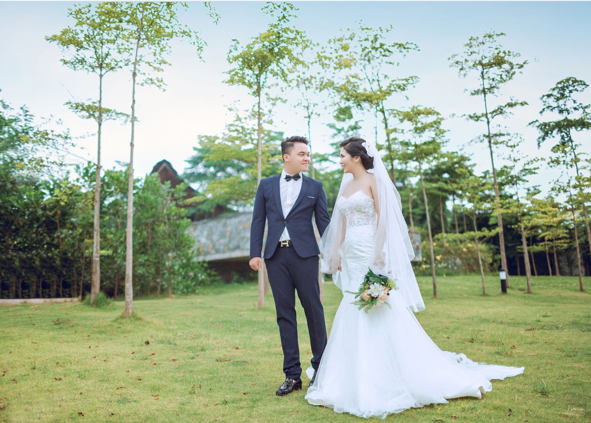 Newlyweds embracing outdoors surrounded by lush greenery