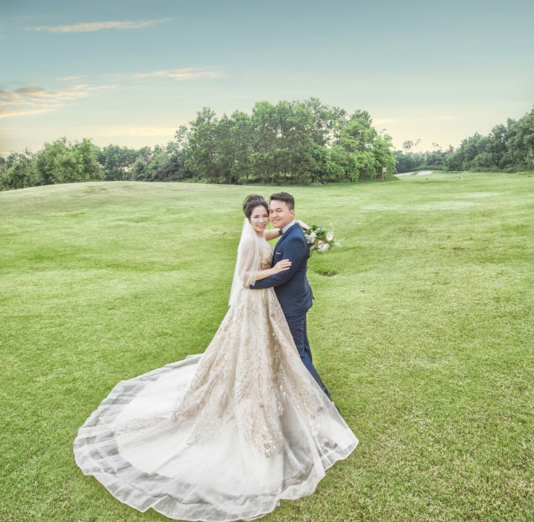Жених и невеста, стоя на поле зеленой травы