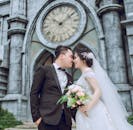 在历史悠久的钟楼前，新娘和新郎分享着浪漫时刻