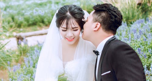 Жених целует невесту на левой щеке