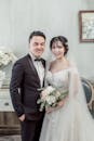 美丽的新娘和新郎手持花束，在室内摆出优雅的姿势，捕捉欢乐的瞬间