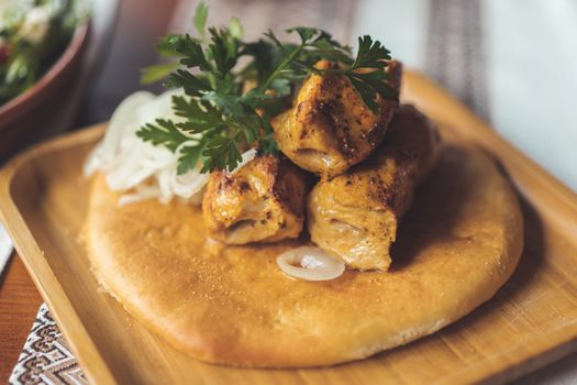 Tasty grilled chicken skewers served on fresh flatbread with herbs and onions.