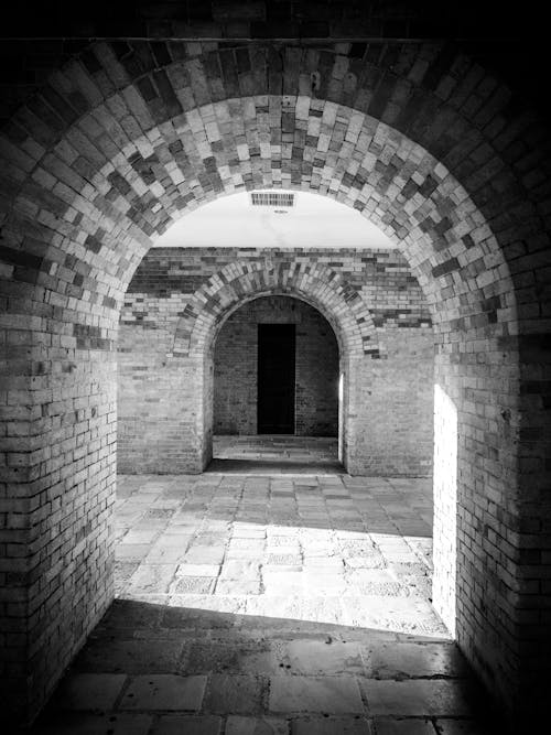 Monochrome Photo of Arch Pathway