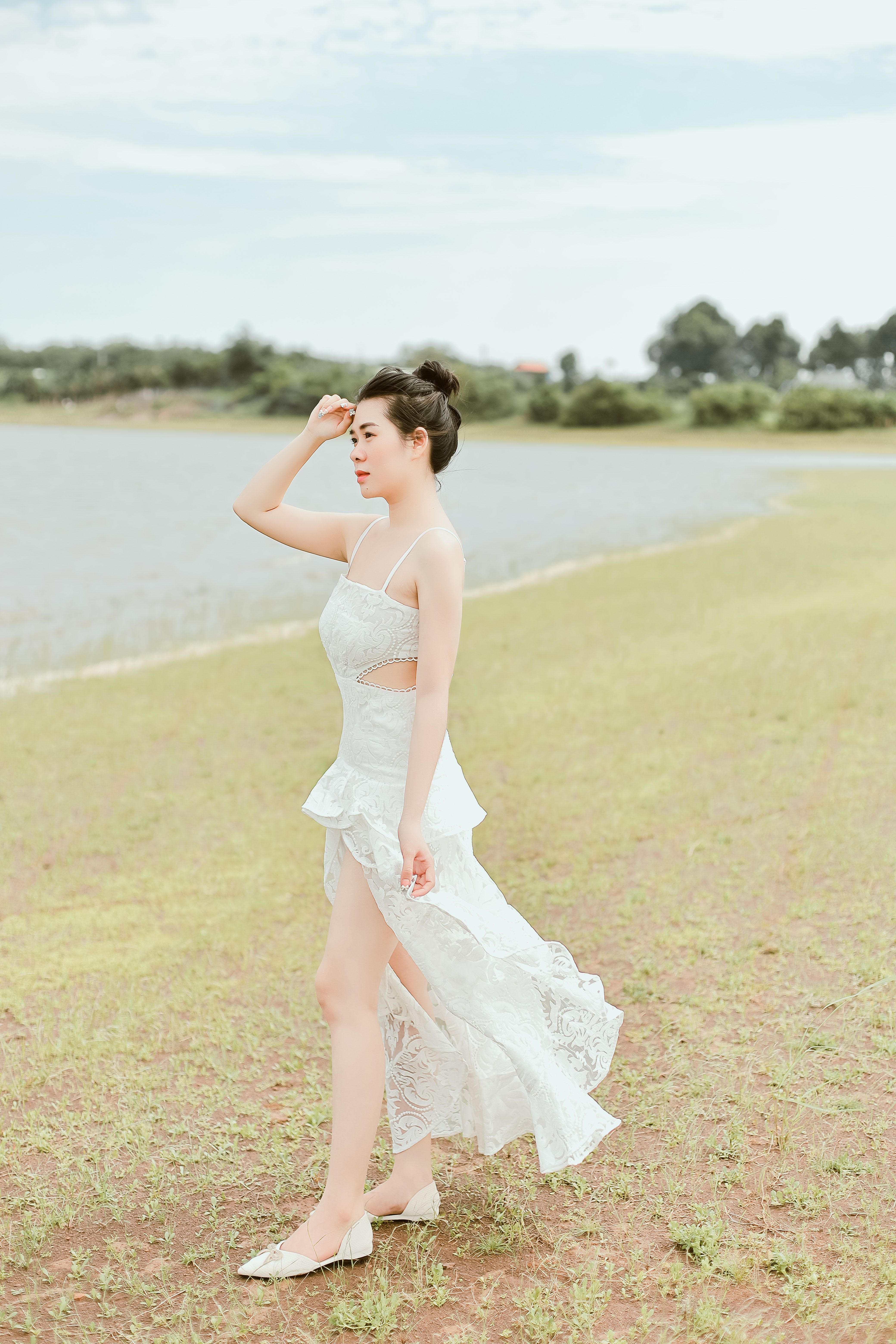 A Woman in White Dress Standing on Green Grass Field · Free Stock Photo