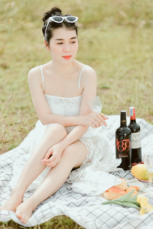 Woman Sitting on Blanket with Wine