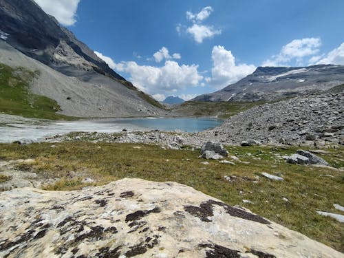 A Lake Between Mountains Under the Blue Sky and White Clouds