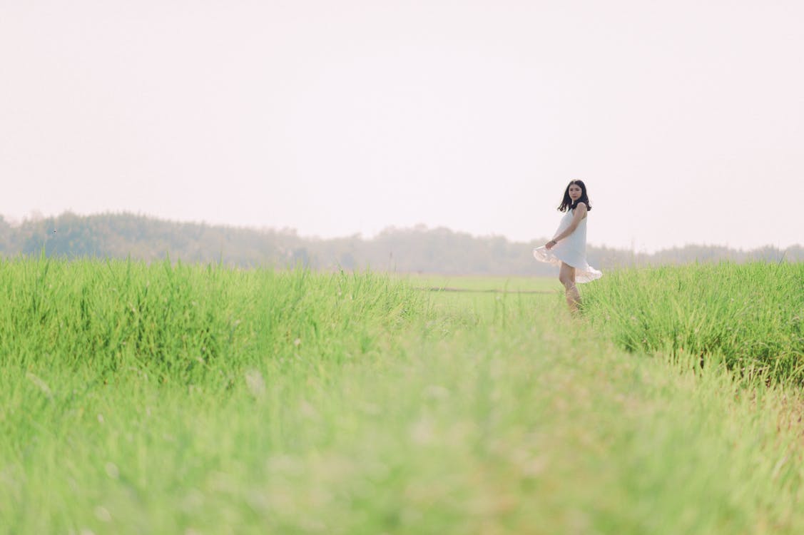Woman in White Dress on Green Grass Field