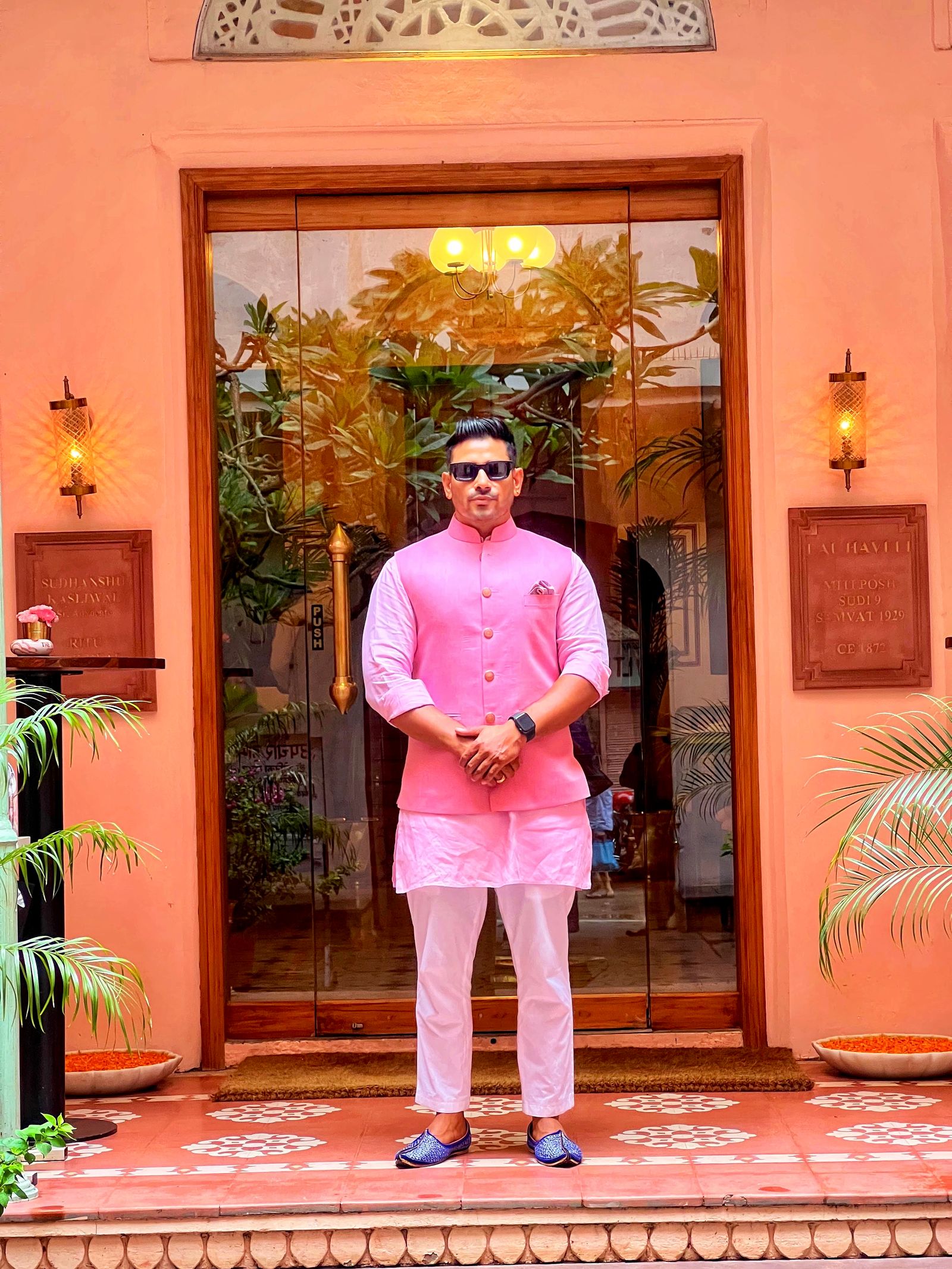 Man in a pink kurta wearing black sunglasses