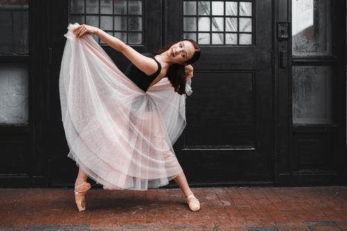 Free A graceful ballerina poses elegantly in front of a black door in Orlando, FL. Stock Photo