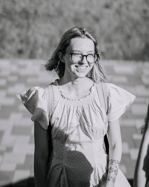 Free A black and white portrait of a smiling woman wearing eyewear and a polka dot dress. Stock Photo