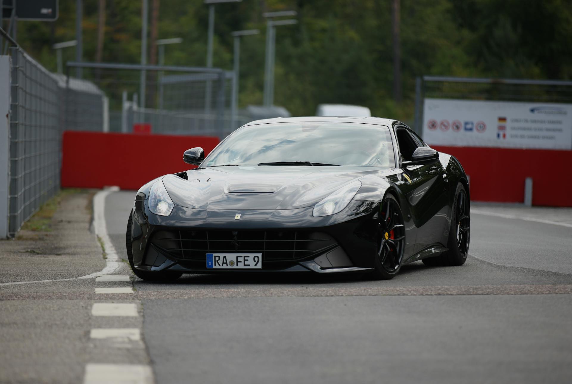 High-performance black Ferrari car on a professional race track, exuding speed and luxury.