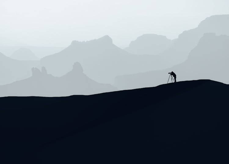 Silhouette Of Photographer On Hills