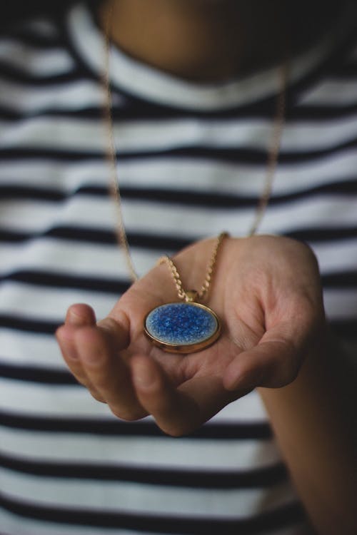 Gratuit Personne Tenant Un Pendentif Doré Photos