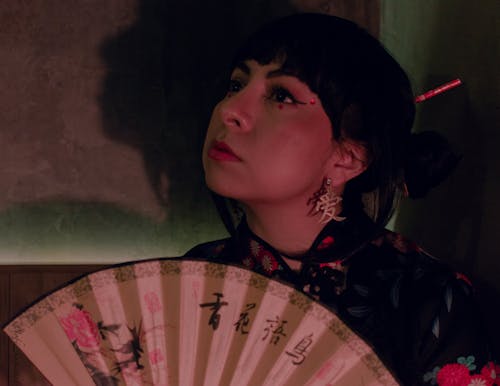 Close Up of a Woman Holding a Paper Fan