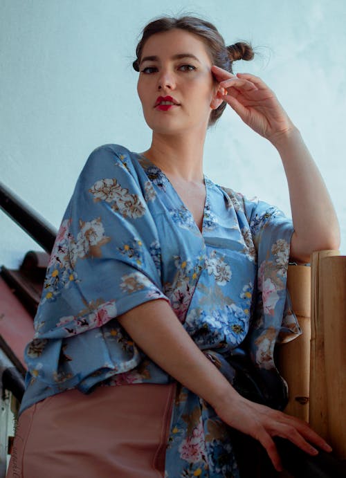 A Woman in Blue Floral Shirt with Her Hand on Her Face