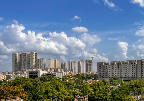 Free Stunning cityscape of Hyderabad's skyline with lush green foliage under a vibrant blue sky. Stock Photo