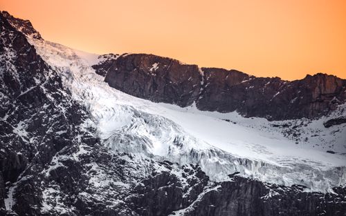 Free Stunning winter landscape of a snowy rocky mountain in Lombardy, Italy at sunset. Stock Photo