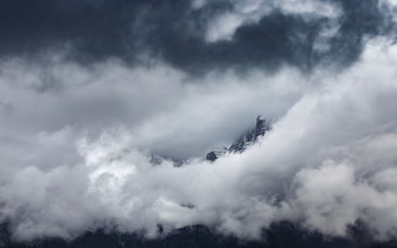 Captivating view of clouds enveloping a mountain peak in Madonna di Campiglio, Italy.