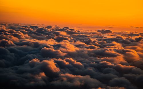Free A breathtaking aerial view of clouds illuminated by a vivid sunset sky. Stock Photo