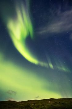 Stunning aurora borealis dancing over Akureyri, Iceland, showcasing vibrant green hues at night.