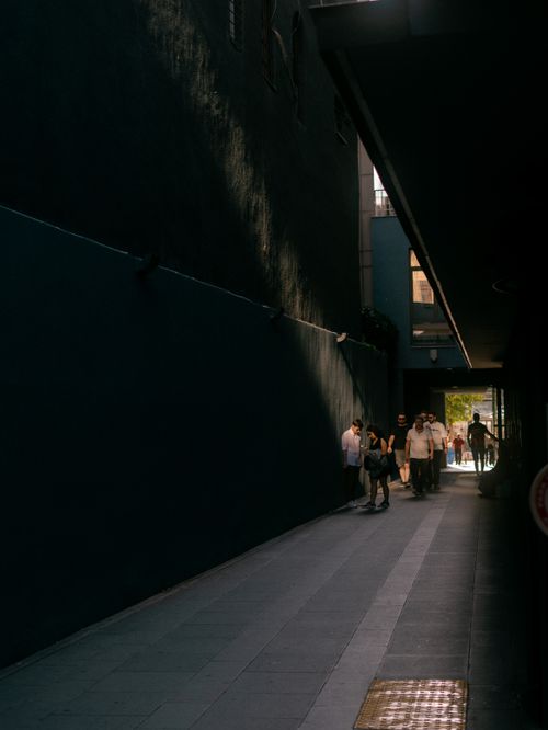 Free A dimly lit alleyway in Istanbul with people walking towards the sunlight. Stock Photo