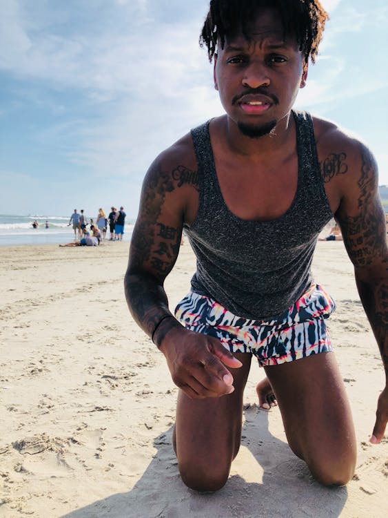 Ilmainen kuvapankkikuva tunnisteilla afroamerikkalainen mies, hiekka, hihaton paita