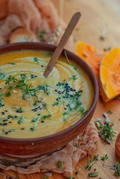 Delicious creamy pumpkin soup garnished with fresh herbs and seeds, perfect for a cozy meal.