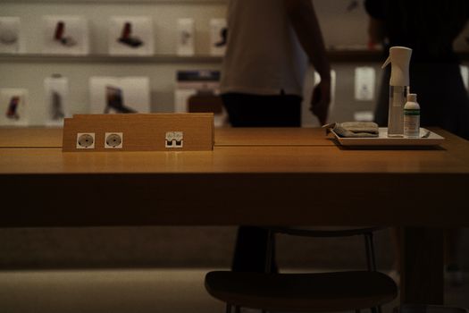 A contemporary store interior showing a wooden table with a charging station and cleaning supplies in Istanbul, Turkey.