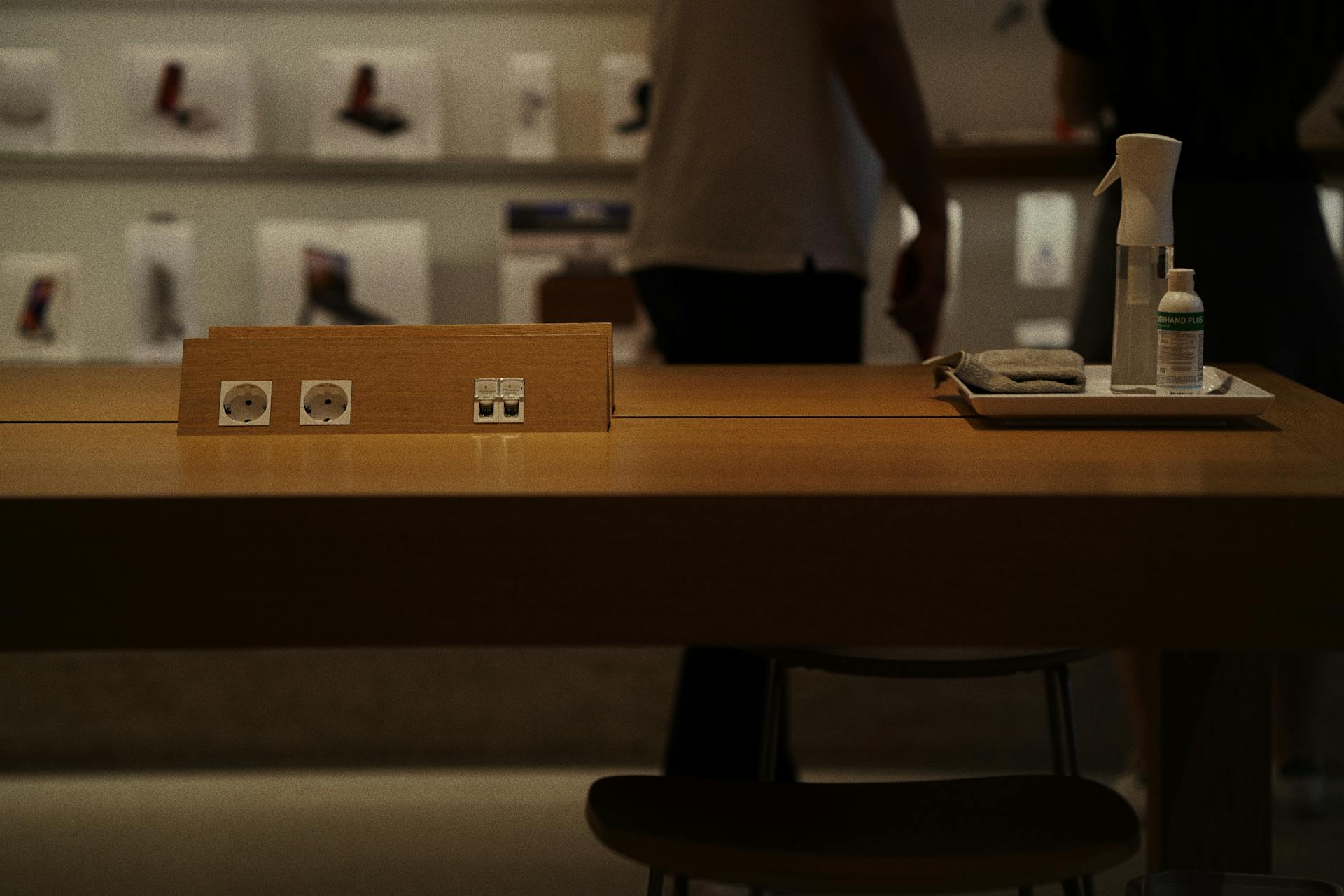 A contemporary store interior showing a wooden table with a charging station and cleaning supplies in Istanbul, Turkey.