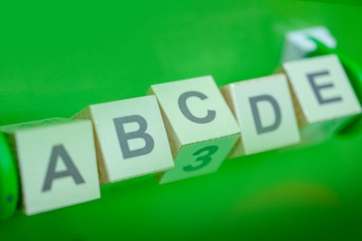 Close-up of alphabet blocks arranged with a green background, perfect for educational themes.