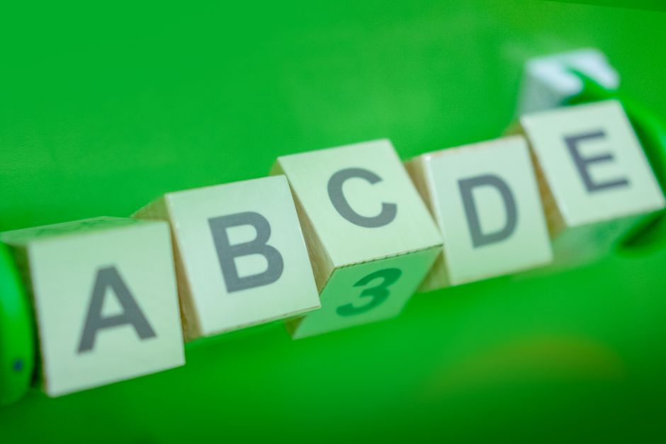 Close-up of alphabet blocks arranged with a green background, perfect for educational themes.