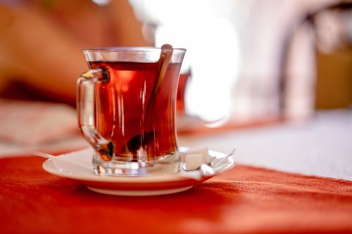 Free Warm close-up of clear glass tea cup on saucer with sugar cubes. Stock Photo