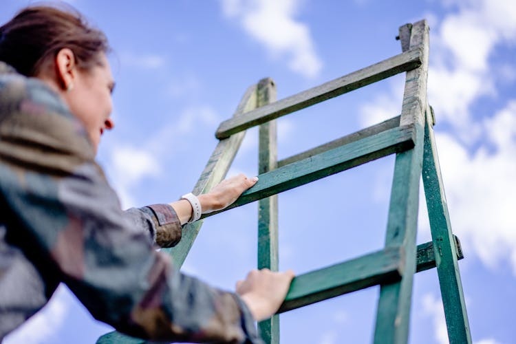 Woman Climbing A Ladder