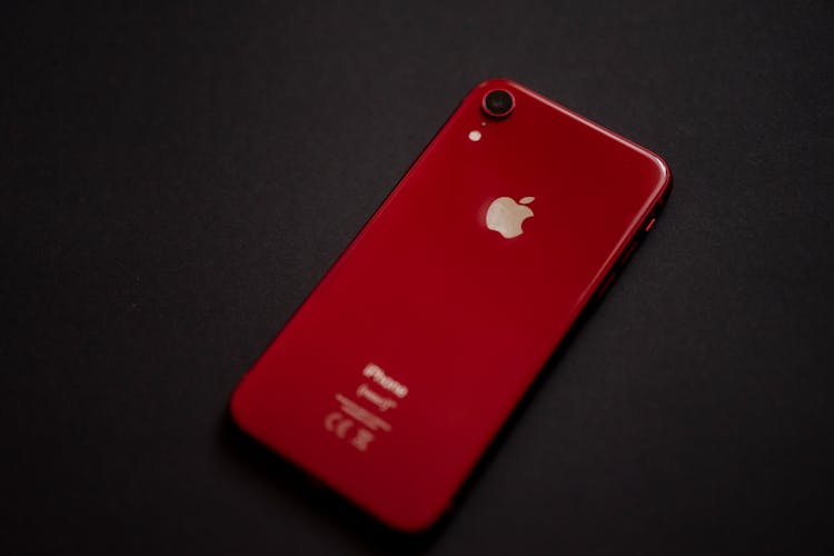 A Red Iphone On Black Surface