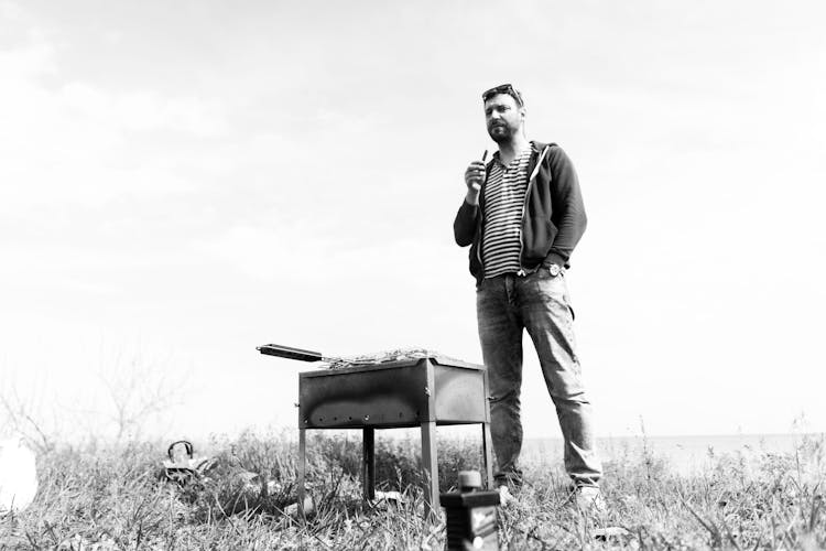 Standing Man Cooking Food On A Barbecue