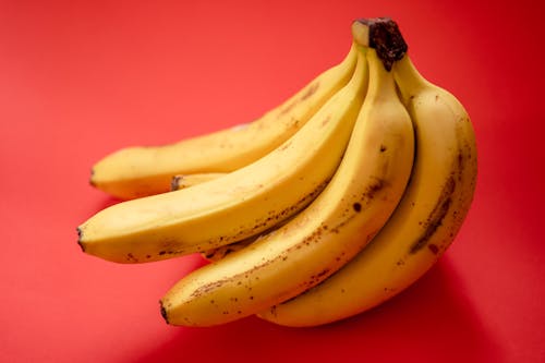 Yellow Banana Fruit on Red Surface