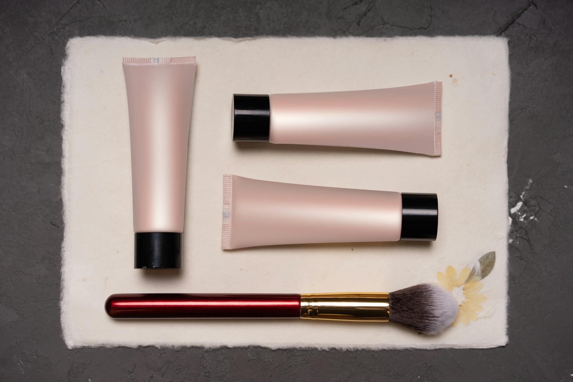 Tubes of Cosmetics to Makeup and a Makeup Brush