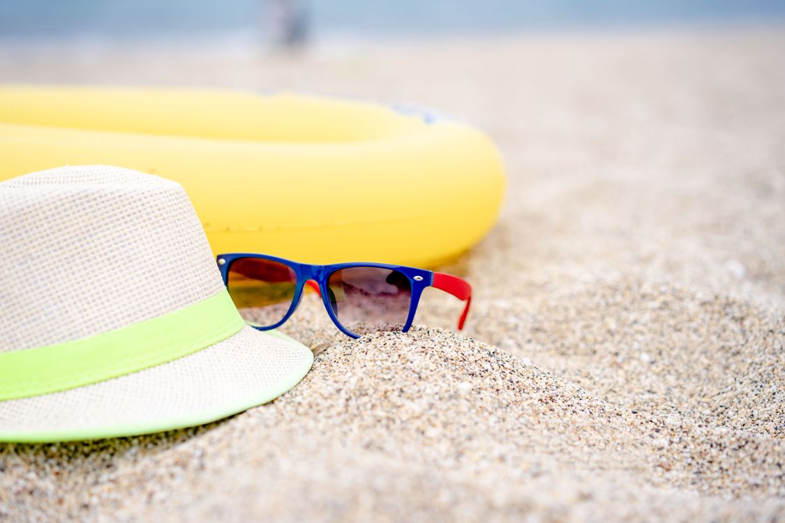 A Hat and Sunglasses on a Beach · Free Stock Photo