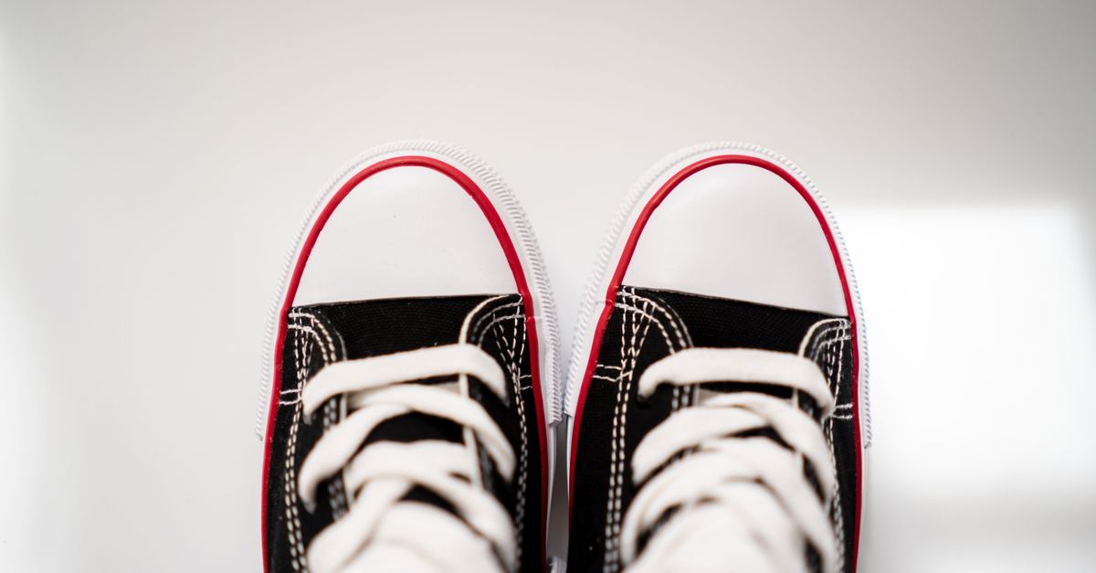 Black and white sneakers viewed from above, placed on a clean white surface with ample negative space.